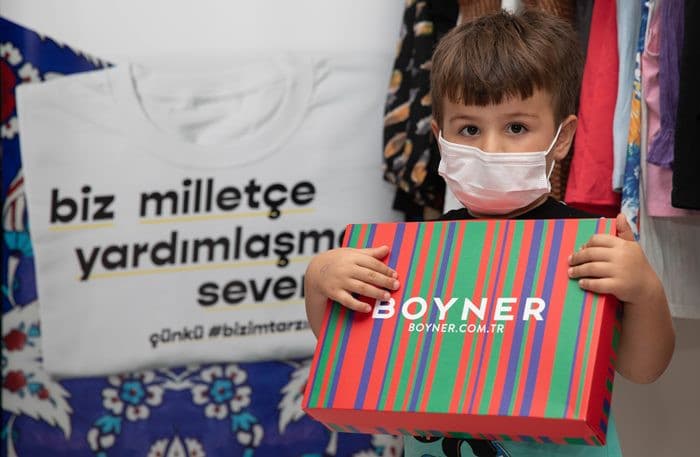 Boyner iyilik paketini taşıyan bir çocuk